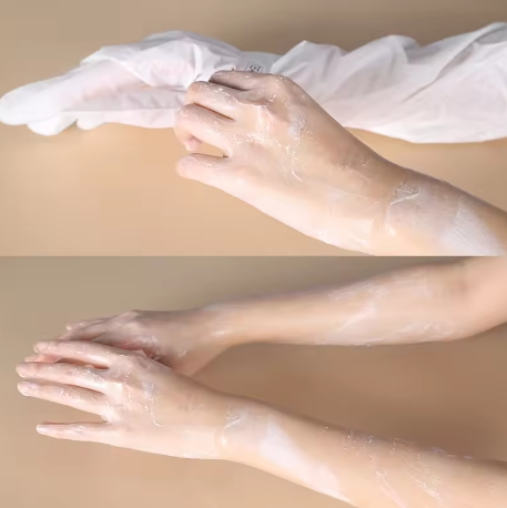 Transparent plastic gloves being worn on hands against a beige background